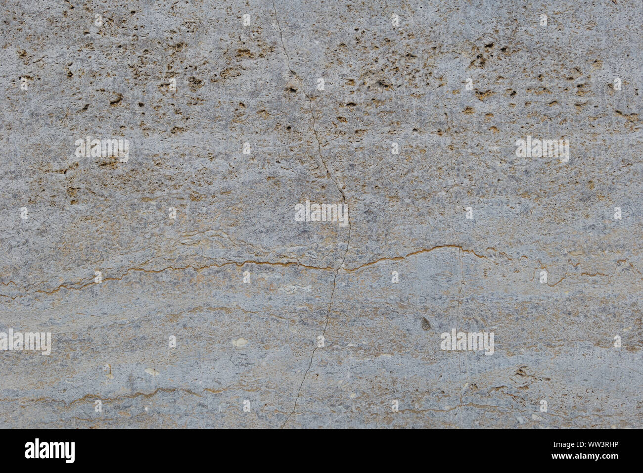 Rough white natural stone travertine with small random cavities. Limestone building material. Stock Photo