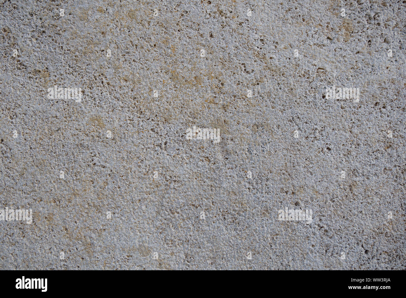 Rough white natural stone travertine with small random cavities. Limestone building material. Stock Photo