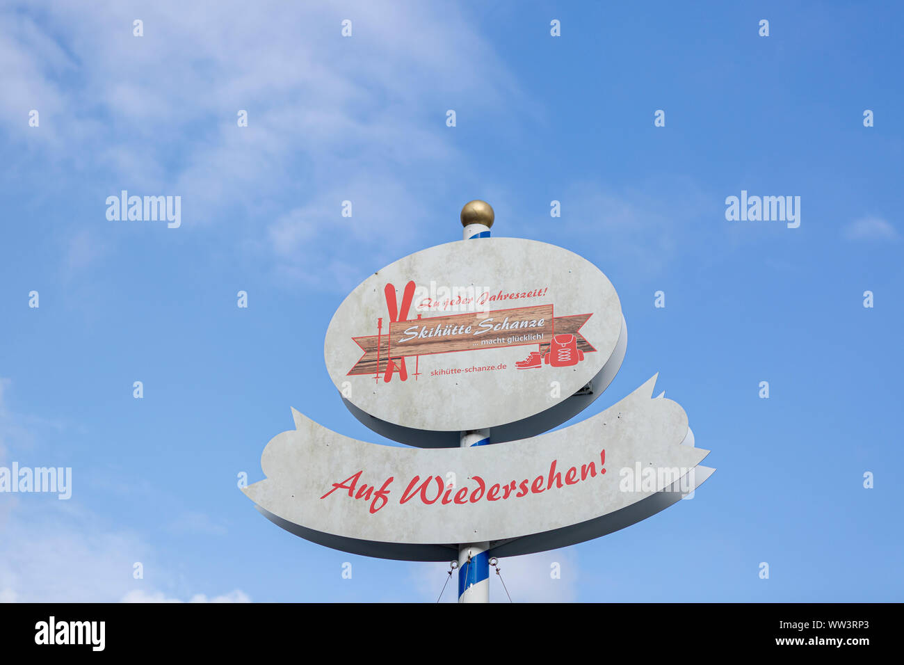 Sign with the word Goodbye in German in the ski region of Sauerland against a blue sky Stock Photo