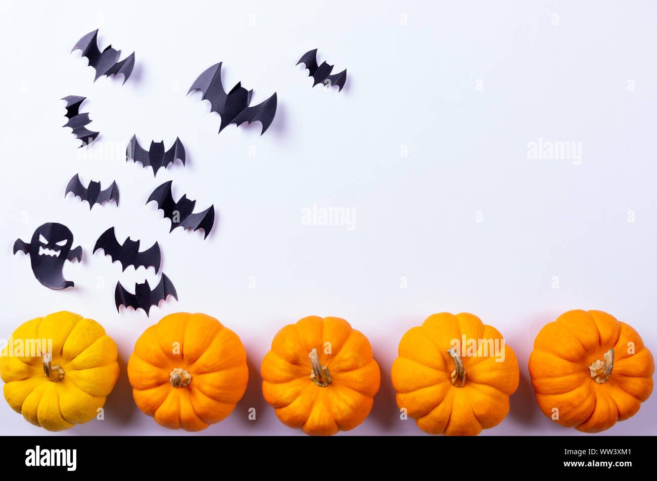 Halloween concept. Flock of black paper bats and fresh pumpkin on white ...