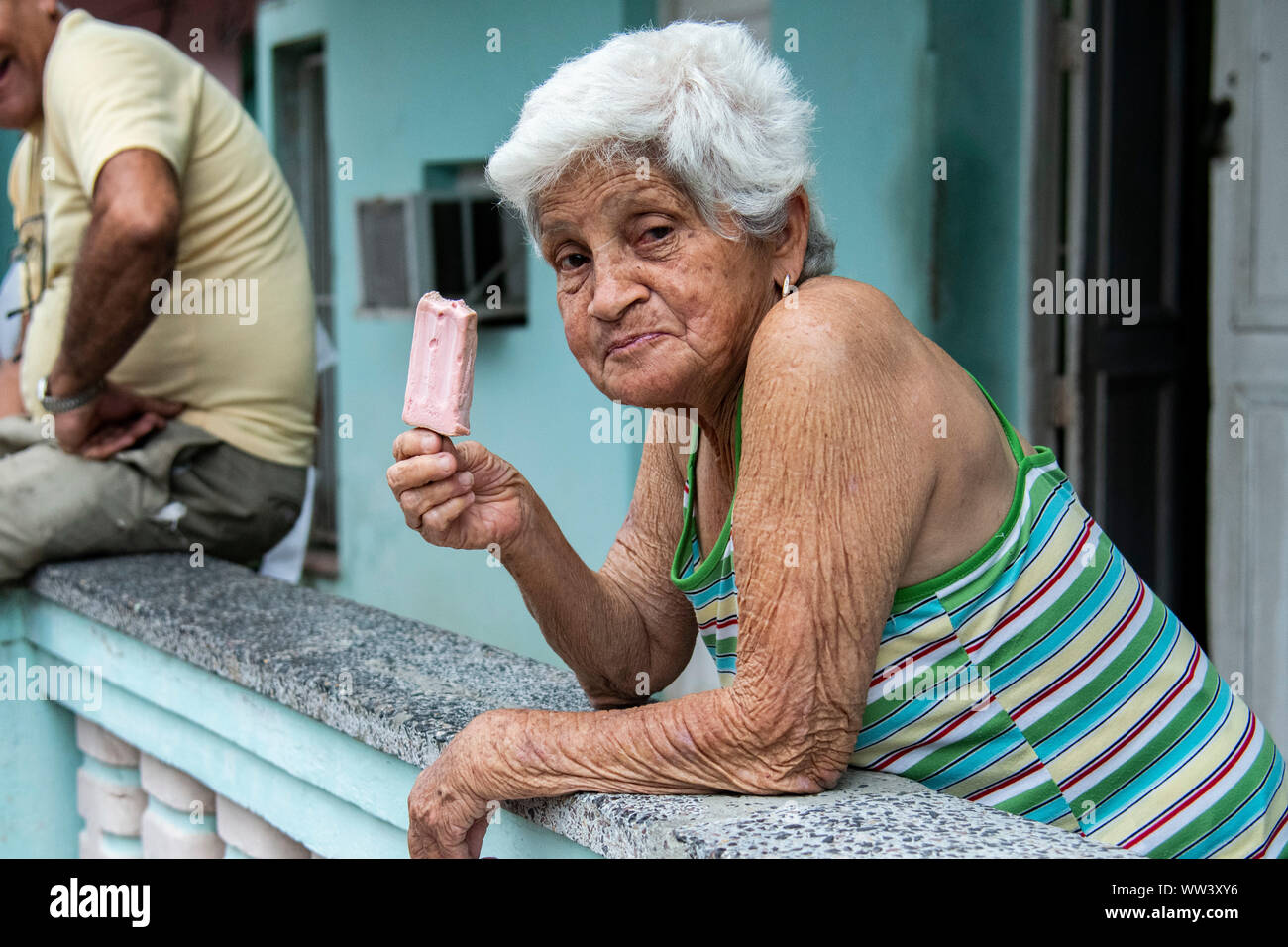 Woman eats an ice cream on a hot day in Cuba Stock Photo