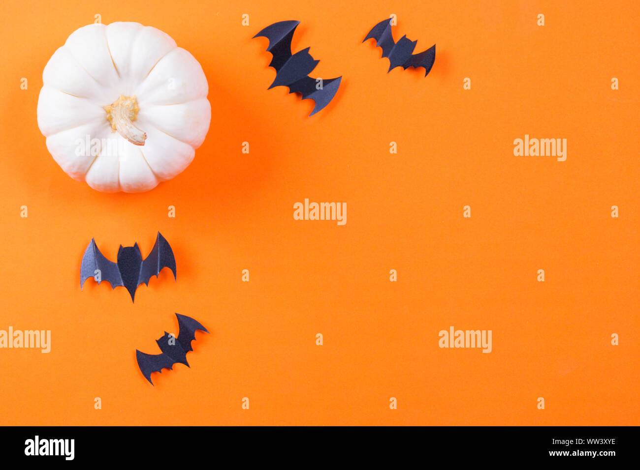 Halloween concept. Flock of black paper bats and fresh pumpkin on ...