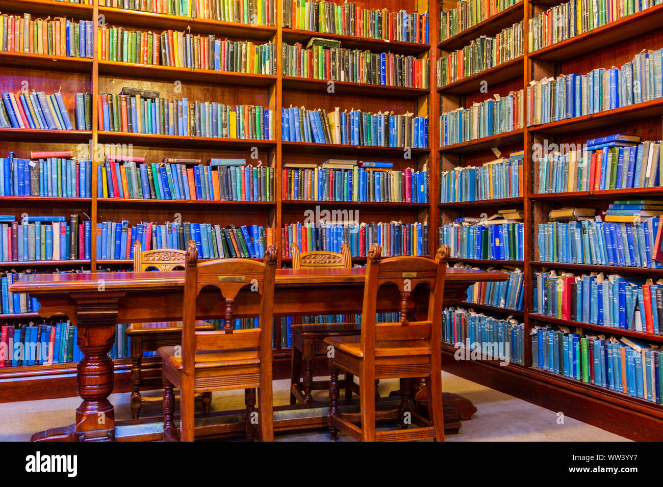 The Corner of a Library with Bookcases and a Table and Chairs Stock