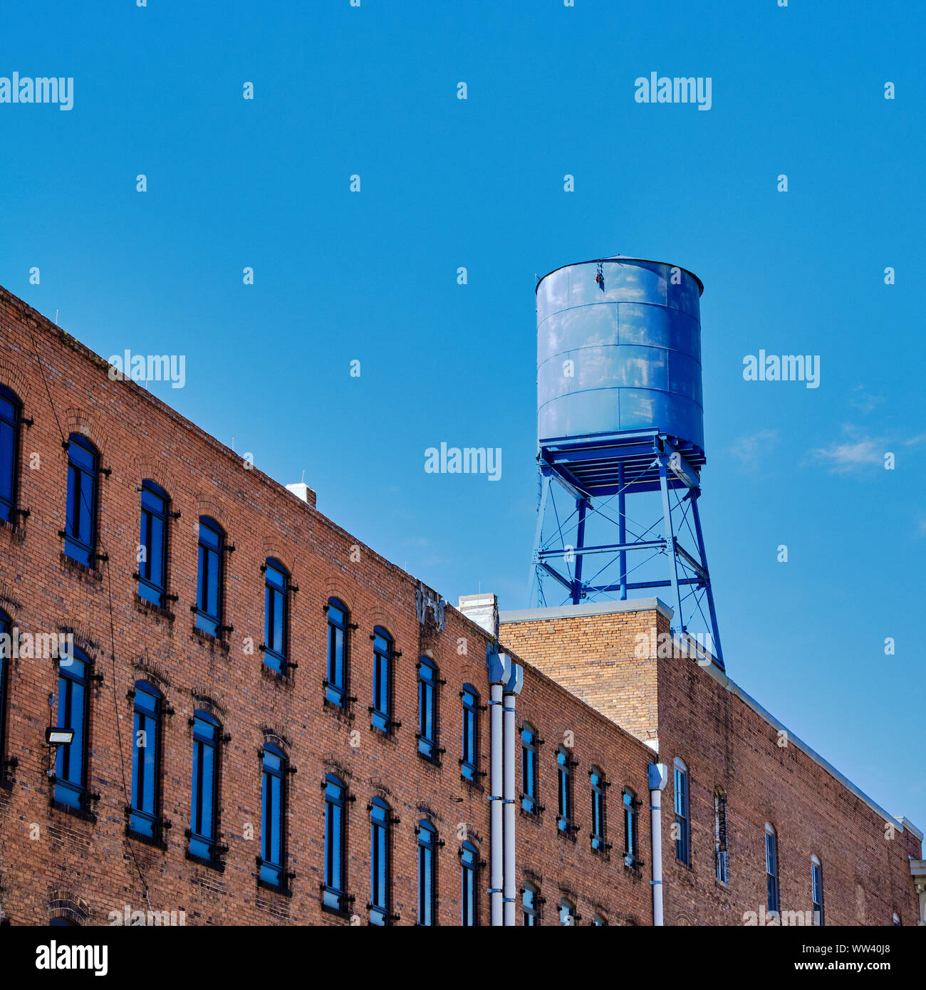 Blue roof top water tower or tank on top of a brick building in downtown Montgomery Alabama, USA. Stock Photo