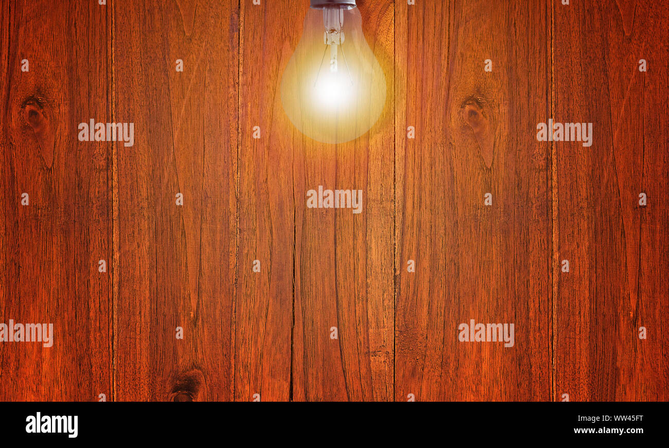 Illuminated red wood wall and light bulb, vintage and retro background ...