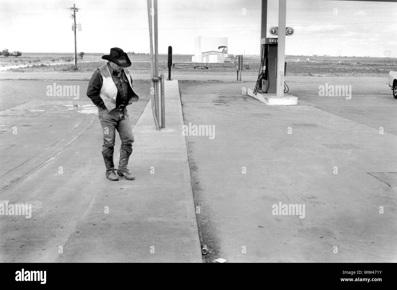 Cowboy 1990s Denton Texas. Lone ranger in his State Hat of Texas, a Ten-gallon hat  and cowboy boots and typical clothing of a ranch worker walking across the forecourt at a petrol gas station 1999 US USA HOMER SYKES Stock Photo
