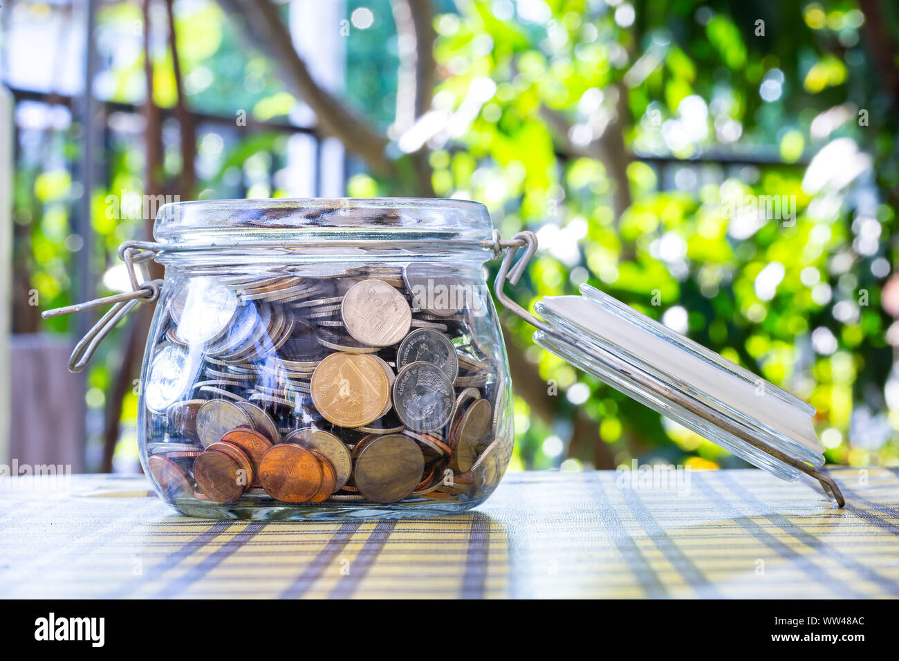 Many coins in glass jar, saving. concept business. Stock Photo