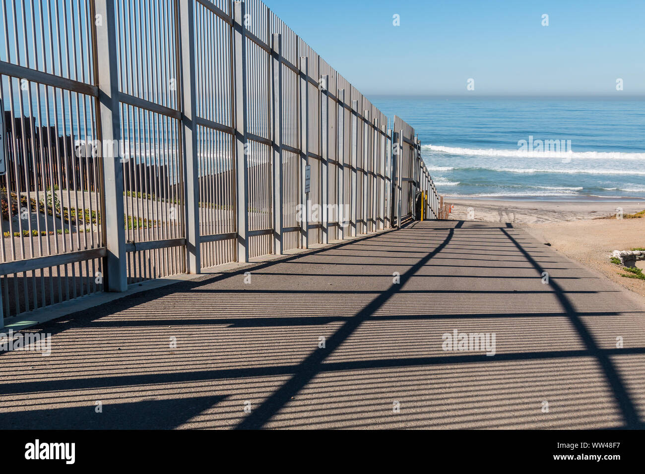 Inner fence of the international border wall which extends out into the Pacific ocean and separating San Diego, California from Tijuana, Mexico. Stock Photo