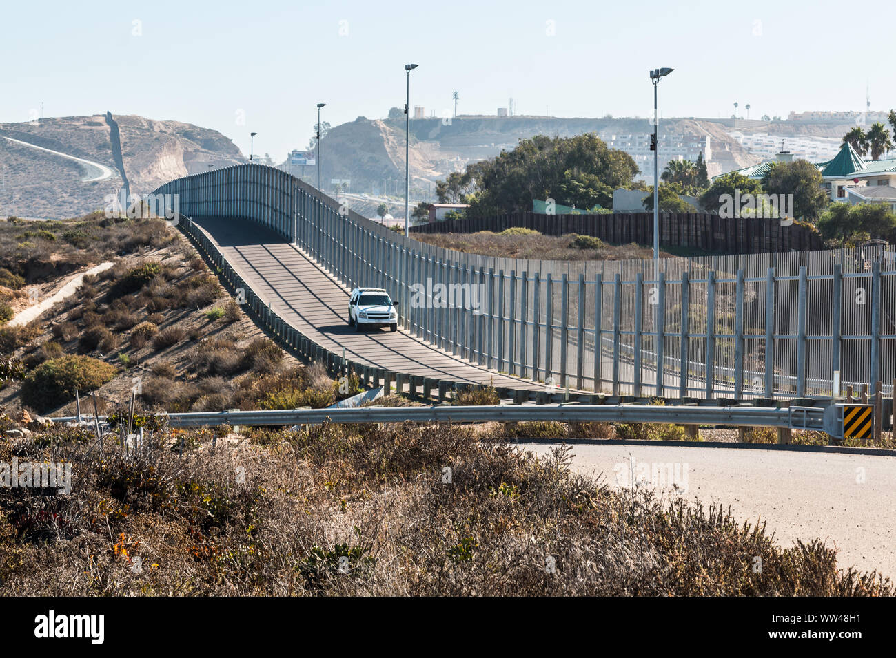 San Diego, California and Tijuana, Mexico international border wall with border patrol vehicle. Stock Photo