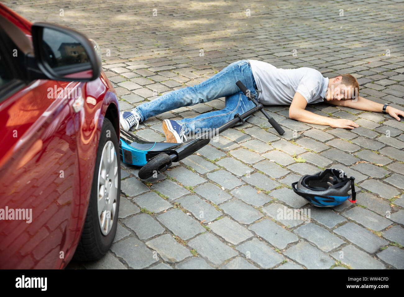 Man After Accident On Electric Scooter Overrun By Car Stock Photo