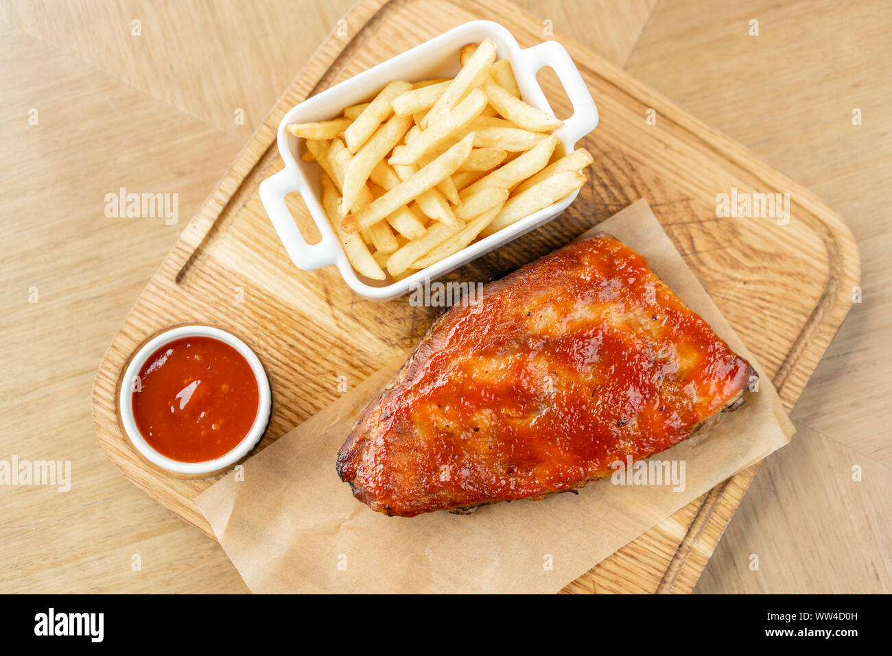Delicious Pork ribs. Full rack of ribs BBQ on wooden plate with french