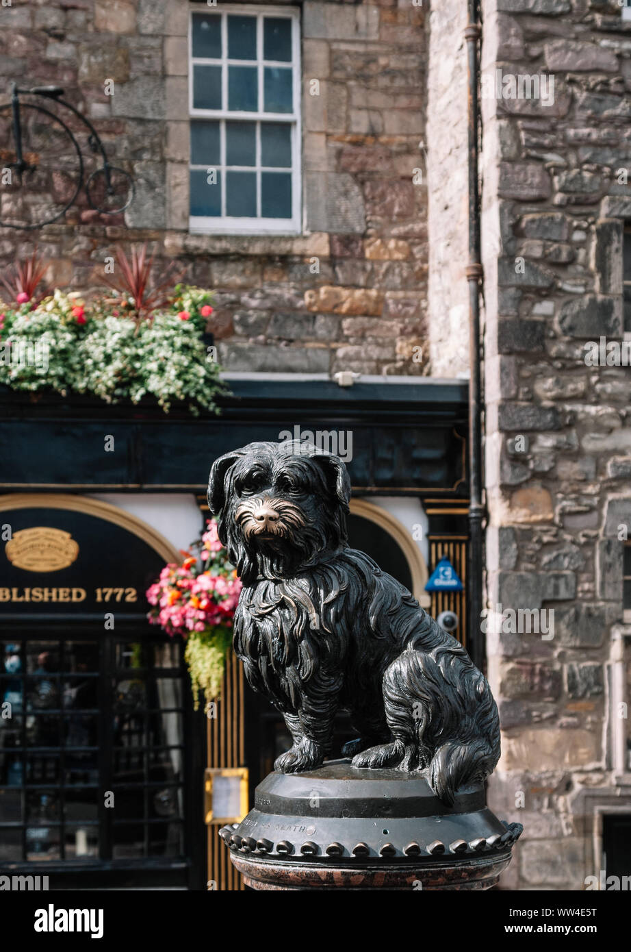 Statue of the famous loyal Skye Terrier dog Greyfriars Bobby and pub of the same name in Edinburgh old town. Stock Photo
