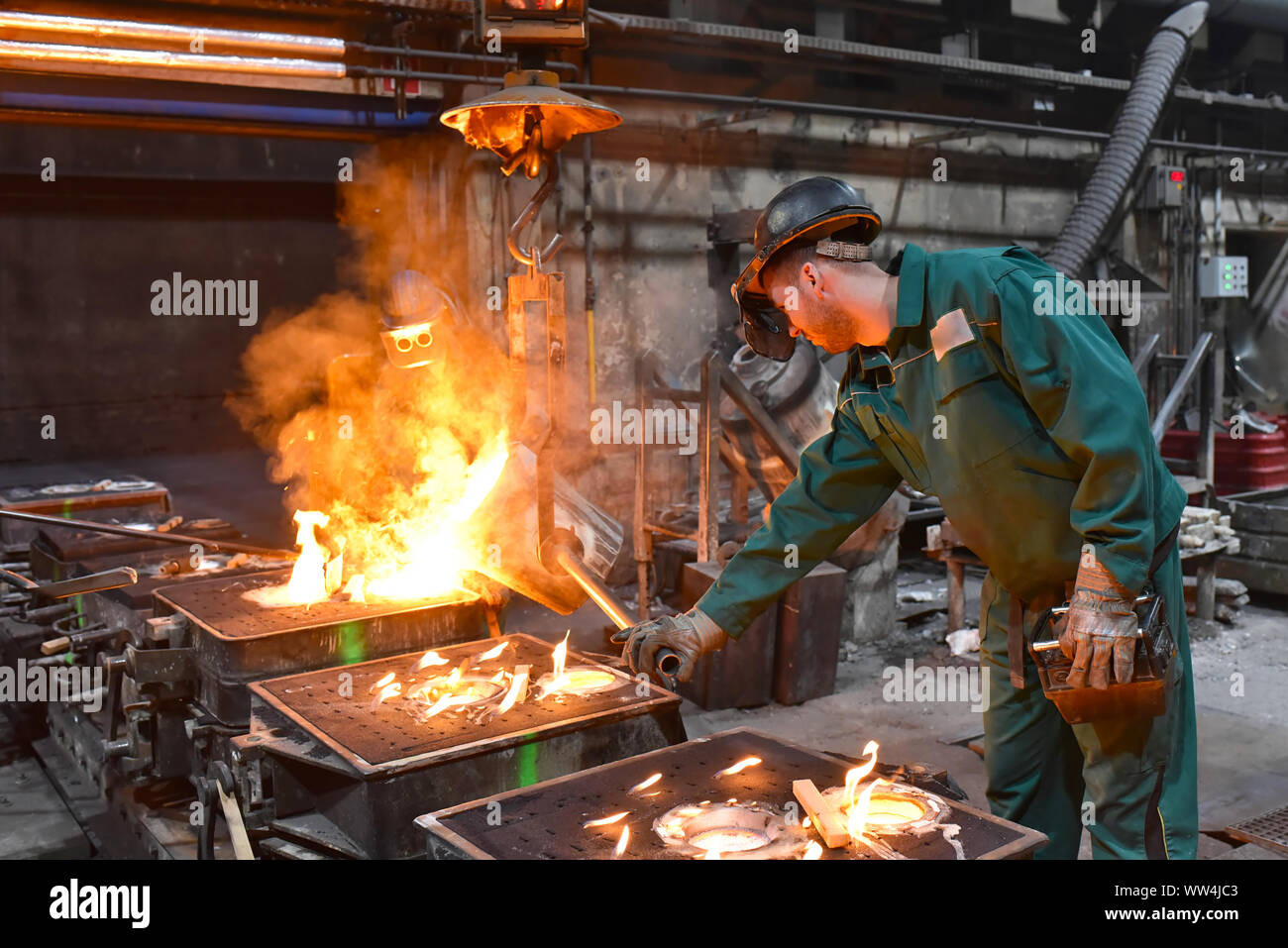 workers in a foundry casting a metal workpiece safety at work and