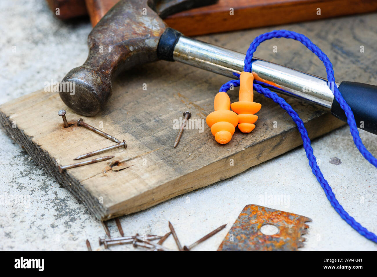 Orange reusable ear plugs in construction site, personal safety equipment concept. Outdoor shooting and shallow depth of field. Stock Photo