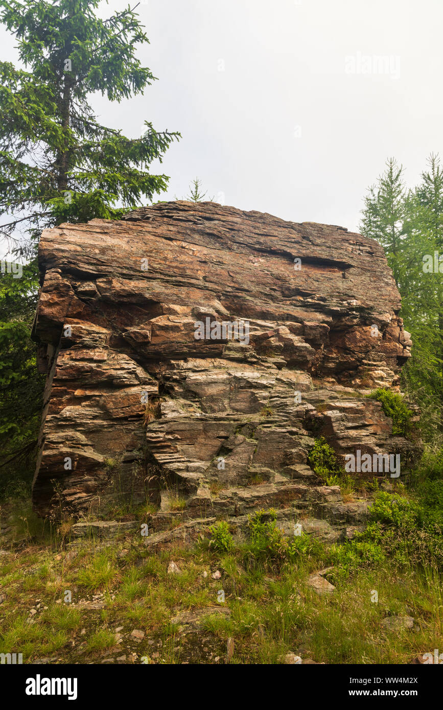 isolated quartzite rock formation with trees around on Kazatelny hill in Jeseniky mountains in Czech republic Stock Photo