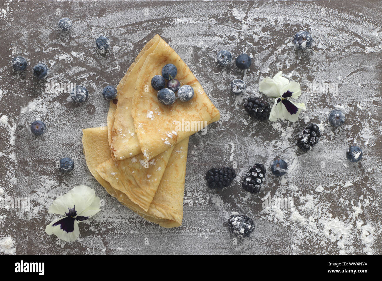Crepes with berries and eatable blossoms Stock Photo