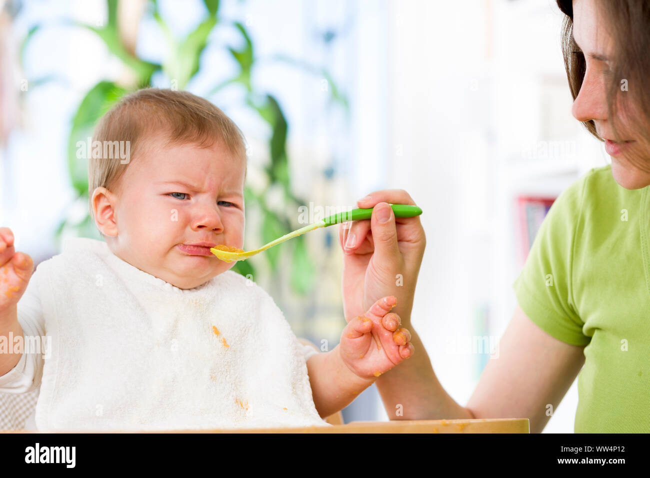 Unhappy baby boy refusing to eat food. Stock Photo
