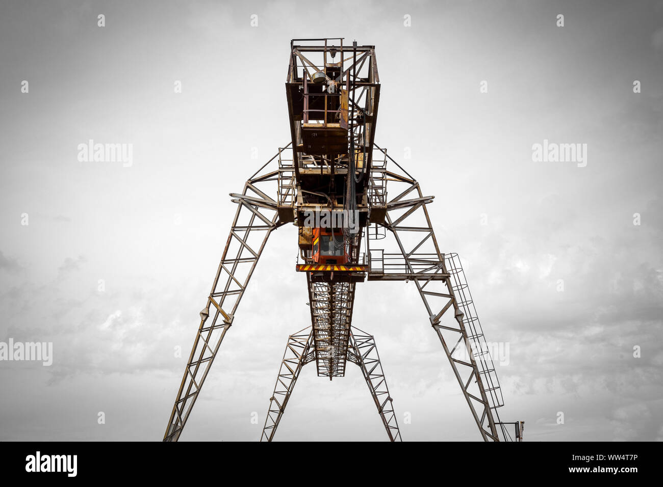 Large metal gantry cranes at a construction site against the blue sky. Type of bearing metal