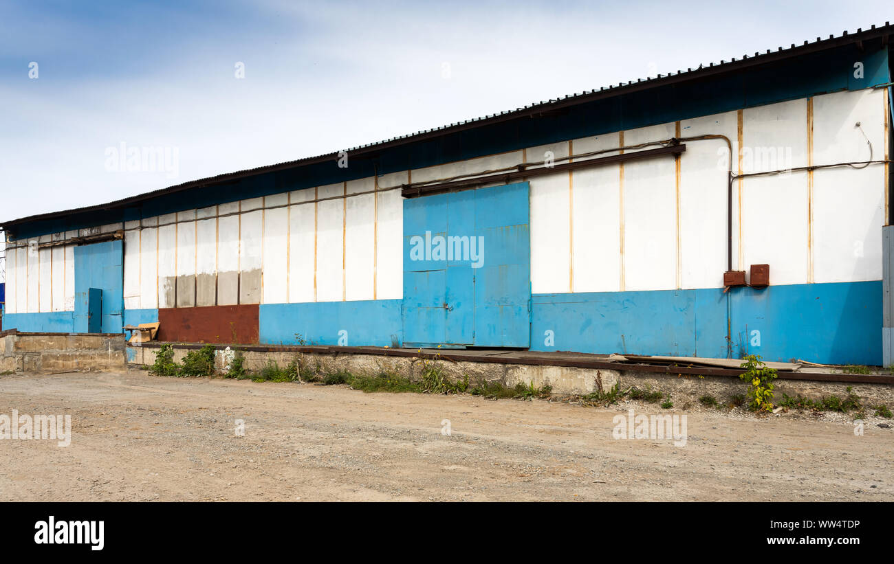 Facade on large industrial building made of metal white and blue panels ...
