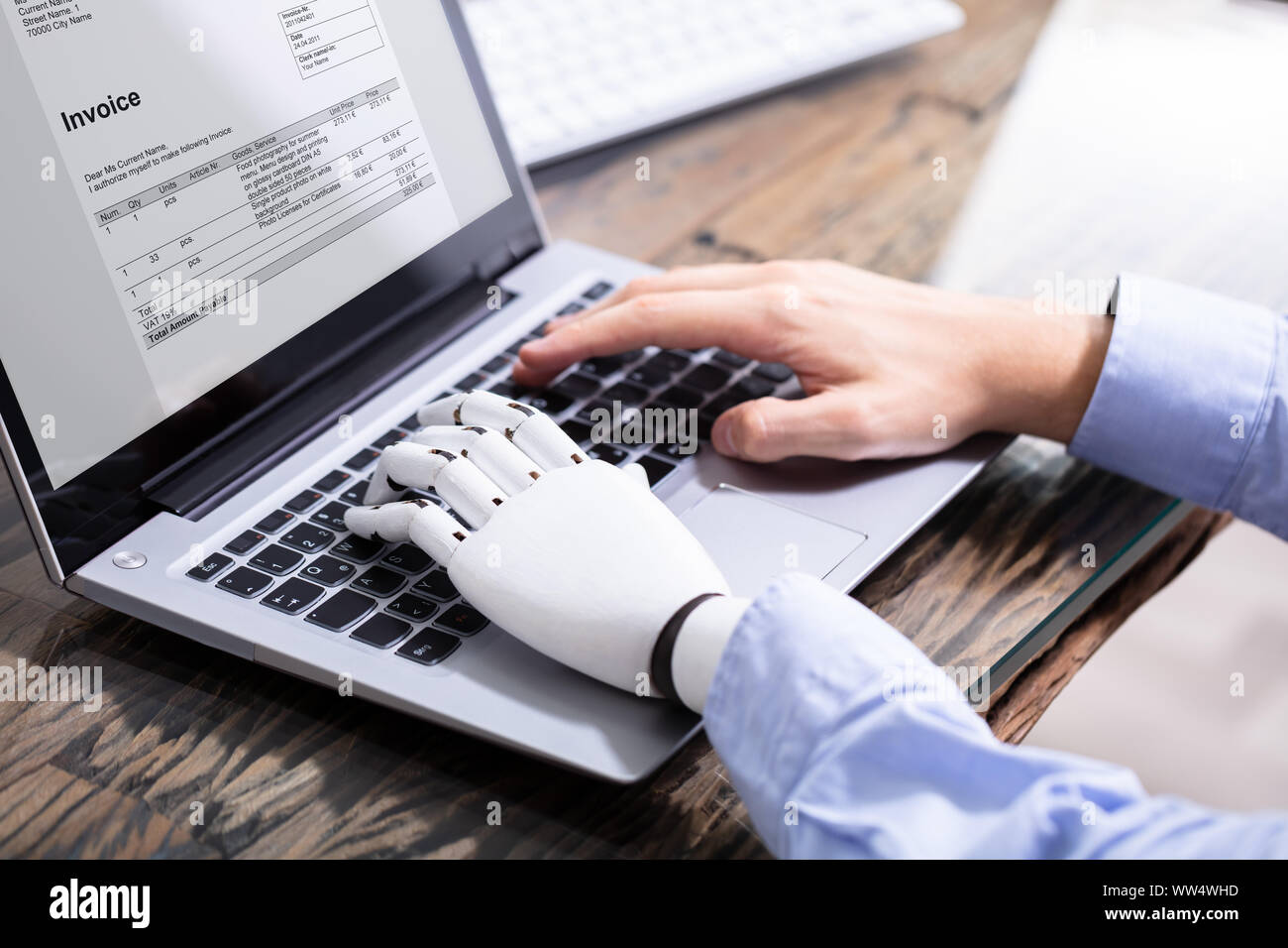 Man With Prosthetic Hand Working On Laptop. Artificial Limb Stock Photo
