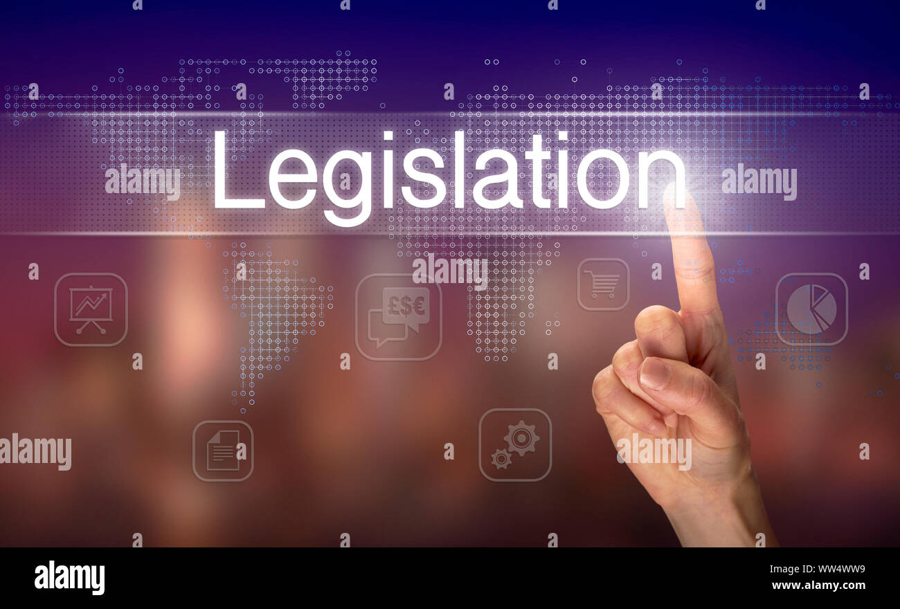 A hand selecting a Legislation business concept on a clear screen with a colorful blurred background. Stock Photo