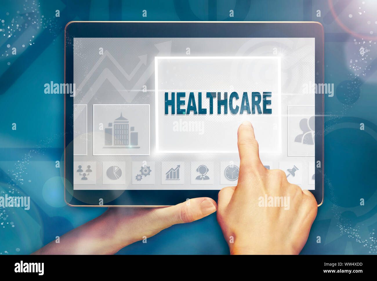 A hand selecting a Healthcare business concept on a computer tablet screen with a colorful background. Stock Photo