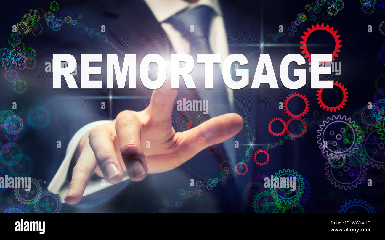 A businessman pressing a Remortgage business concept on a graphical display of cogs Stock Photo