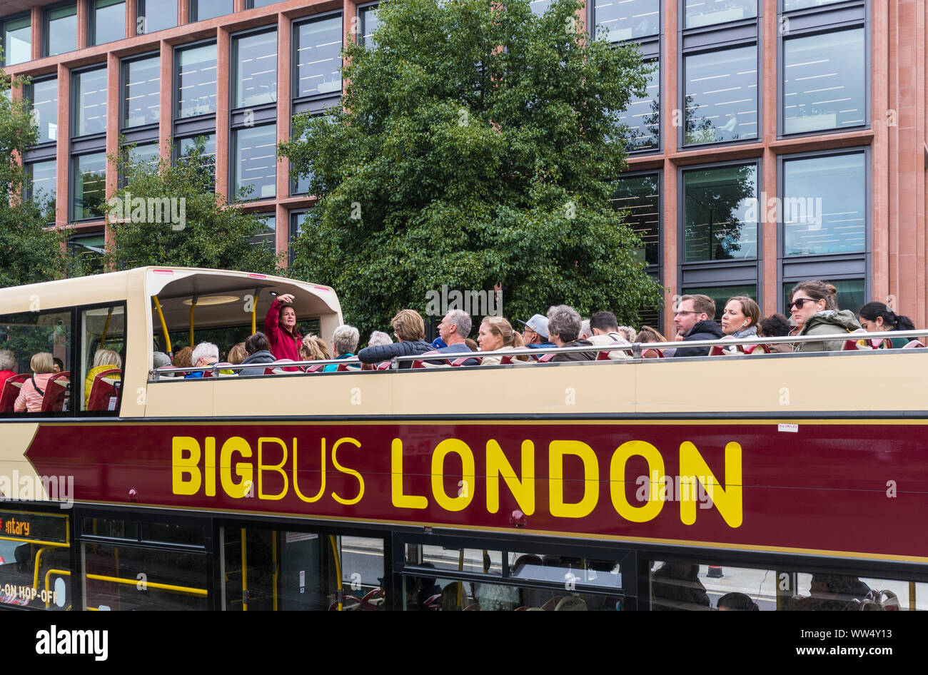 Bis Bus tour on an open top bus in London, with a tour guide speaking to tourists in the City of London, England, UK. Big Bus Tours London. Stock Photo