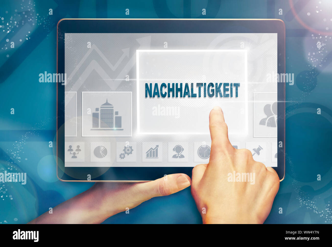 A hand holiding a computer tablet and pressing a Sustainability "Nachhaltigkeit" business concept. Stock Photo