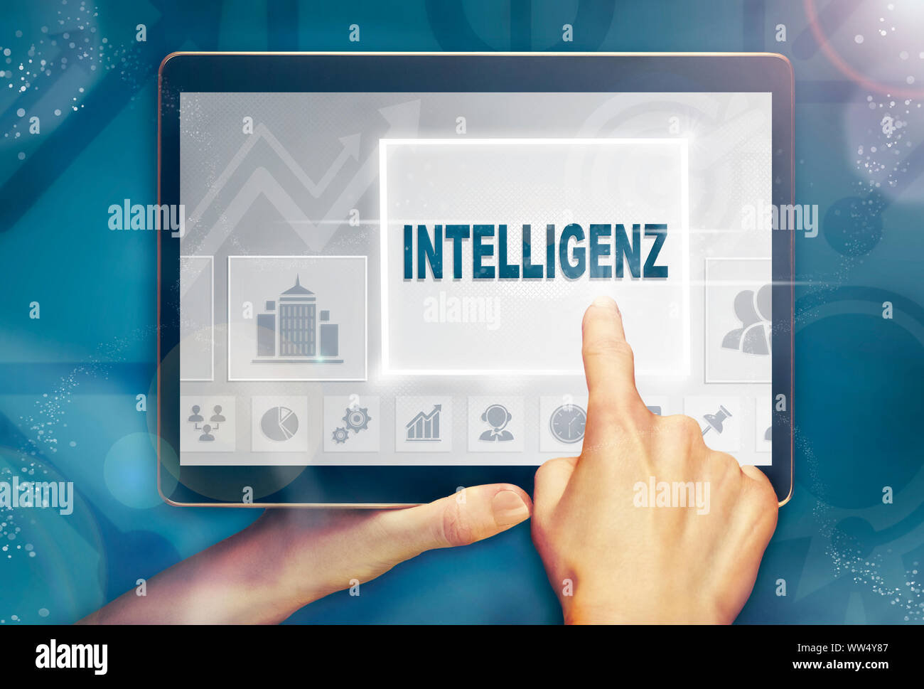 A hand holiding a computer tablet and pressing a Intelligence 'Intelligenz' business concept. Stock Photo
