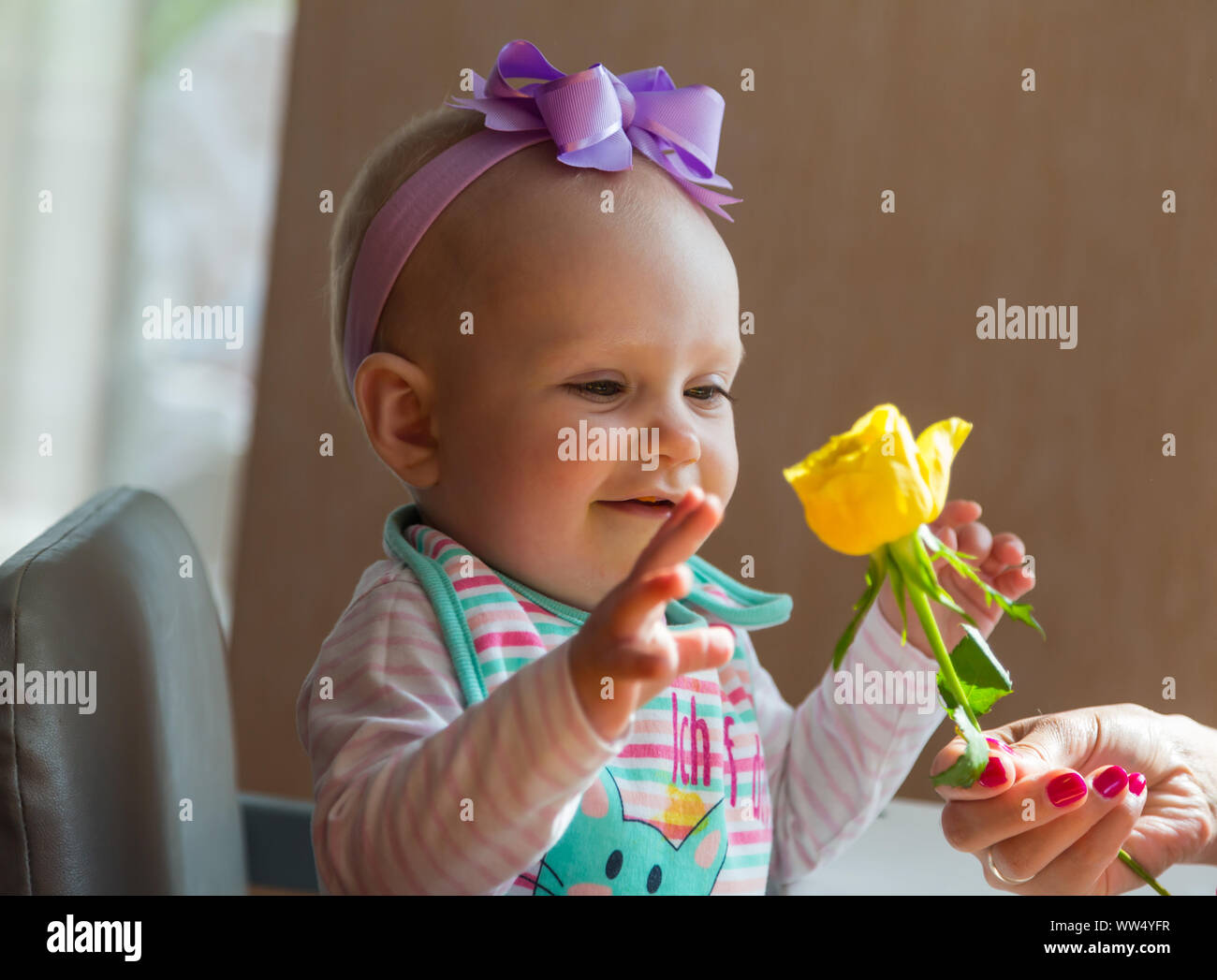 Baby girl with a flower smiling Stock Photo