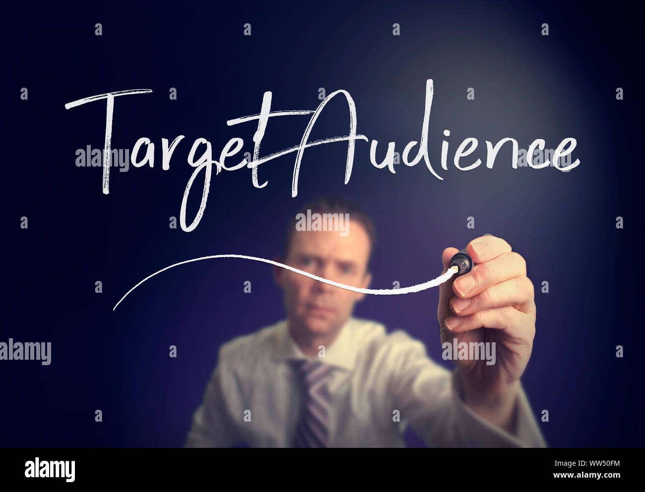 A businessman writing a Target Audience concept with a white pen on a