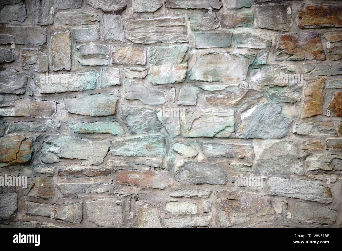 A striking wall with differently coloured and corroding stones, Stock Photo