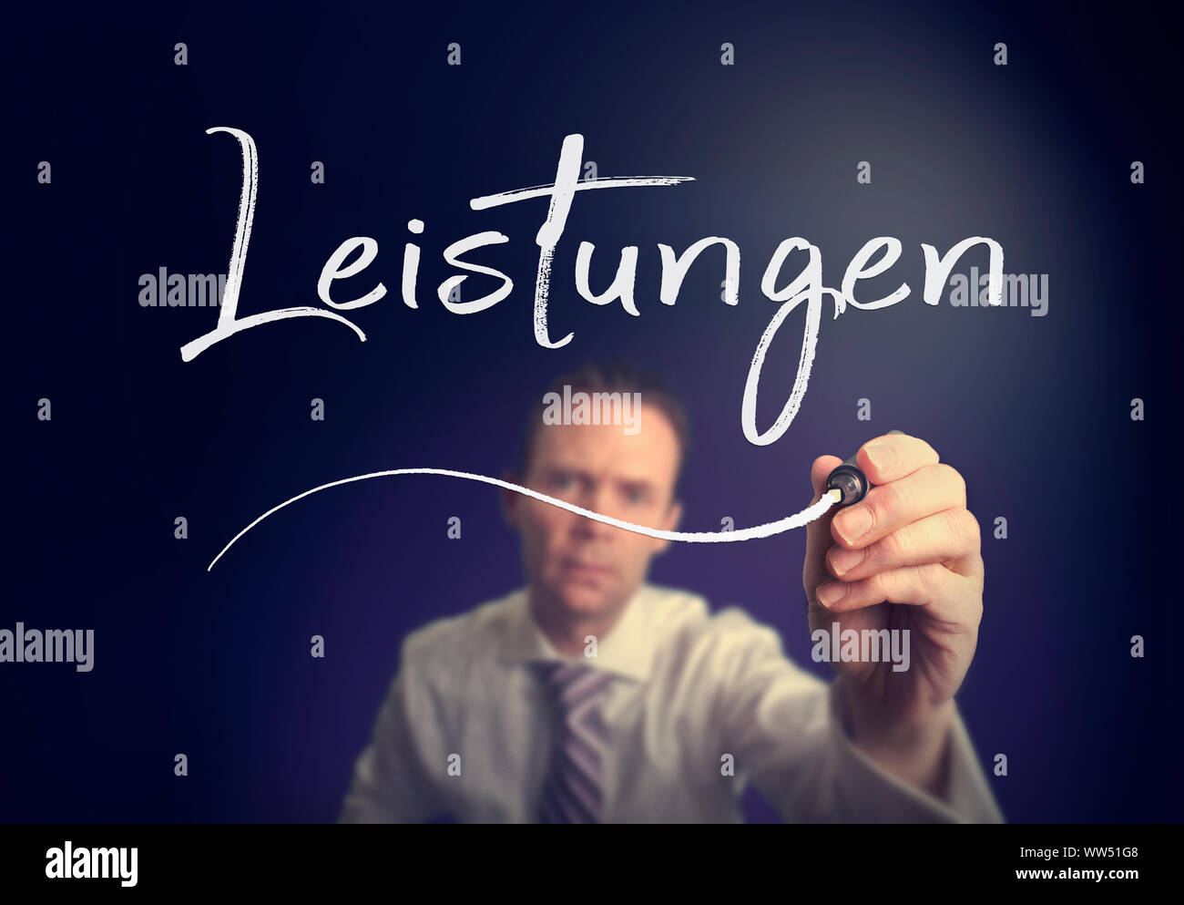 A businessman writing a Services 'Leistungen' concept in German with a white pen on a clear screen. Stock Photo