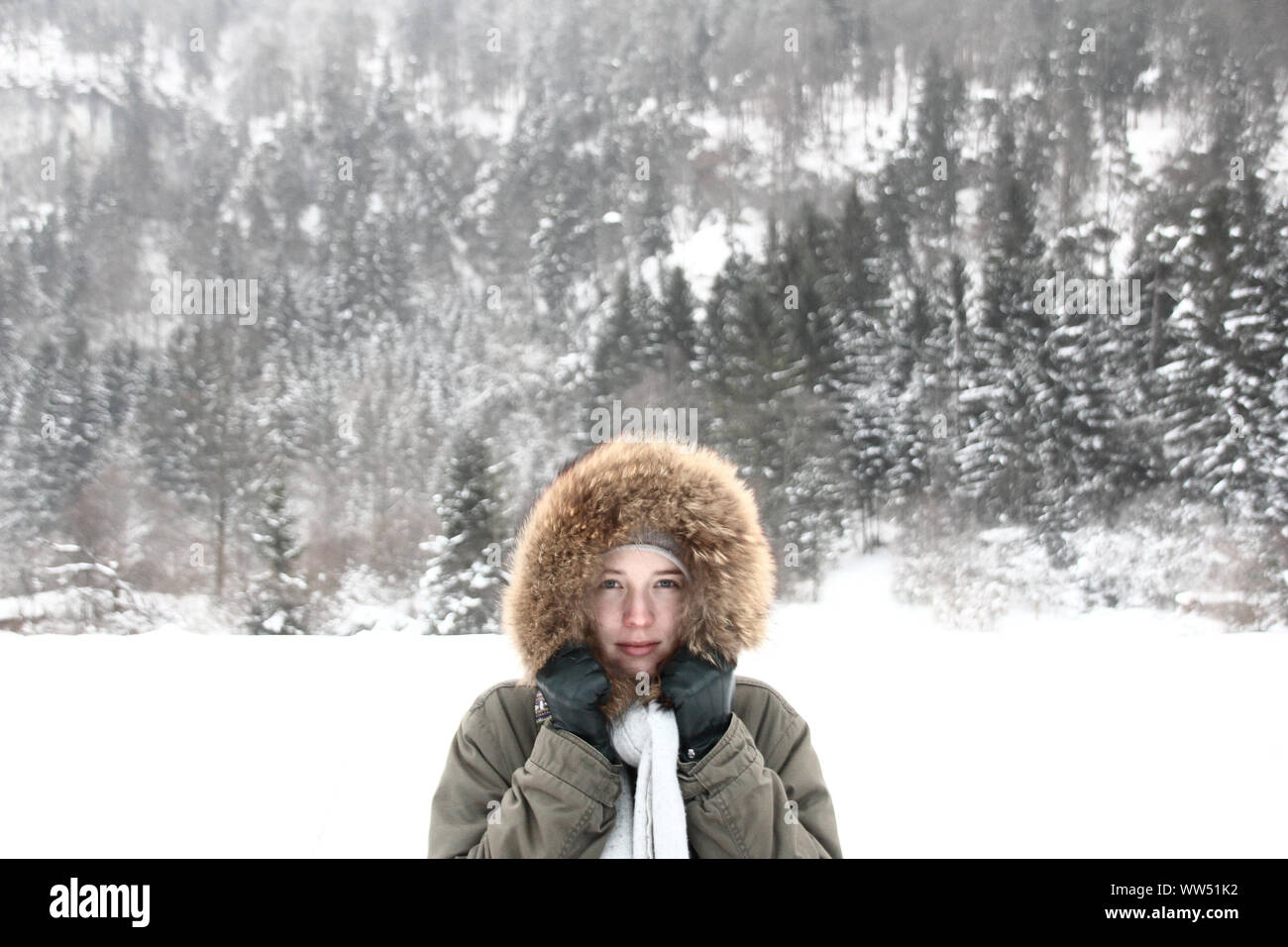 Young woman with fur hood in wintry landscape, Stock Photo
