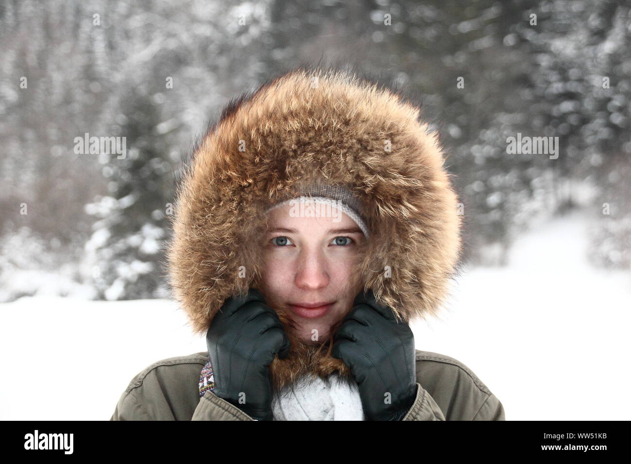 Young woman with fur hood in wintry landscape, close Stock Photo