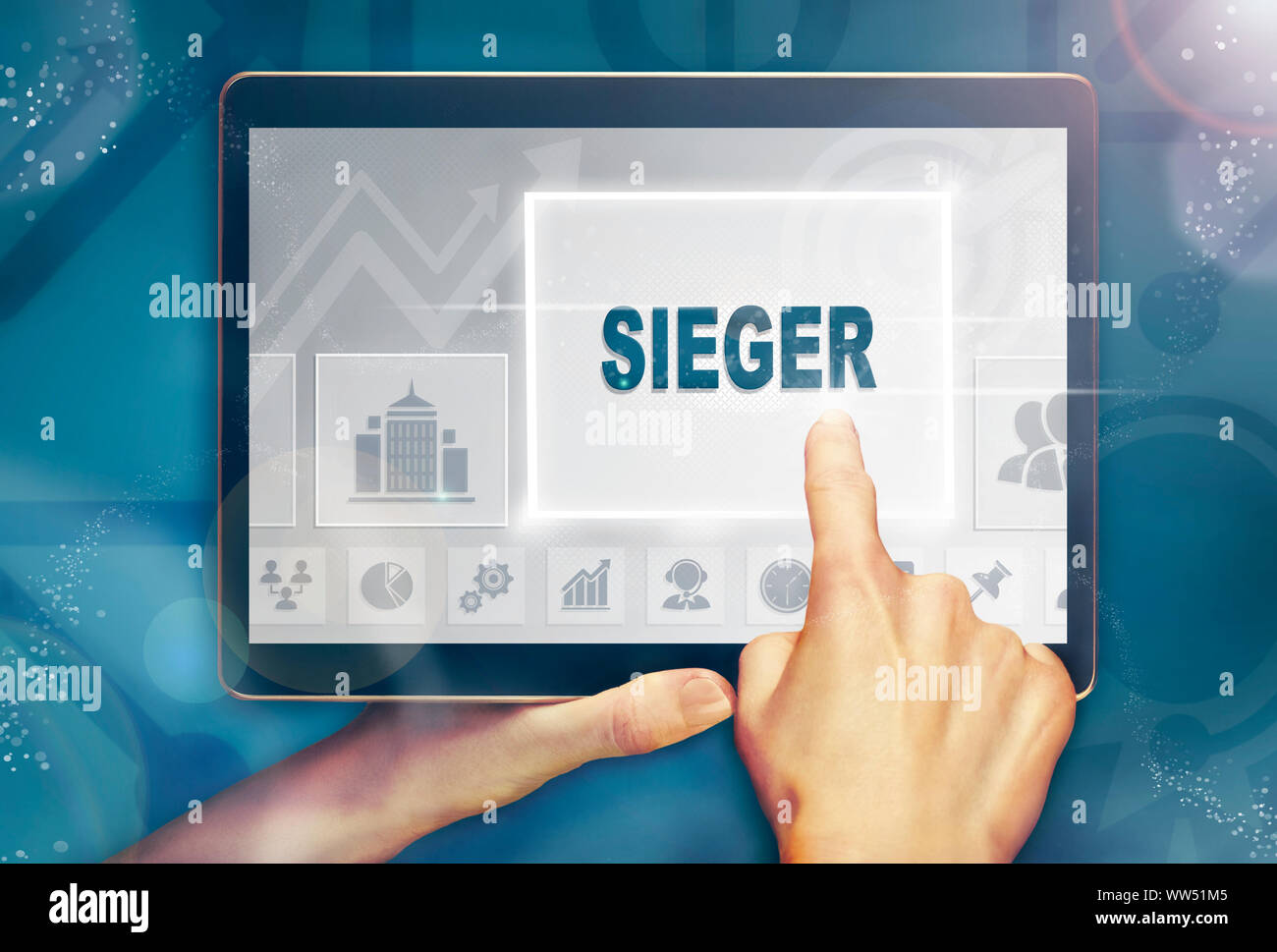 A hand holiding a computer tablet and pressing a Winner "Sieger" business concept. Stock Photo