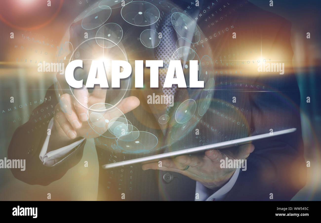 A hand selecting a Capital business concept on a futuristic computer display. Stock Photo