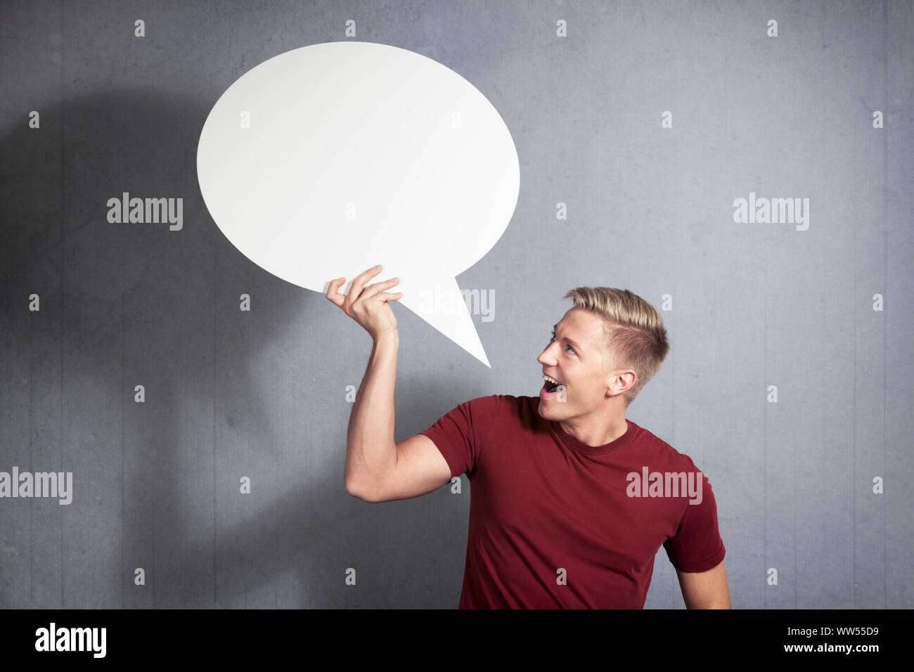 Joyous man holding empty speech balloon. Stock Photo