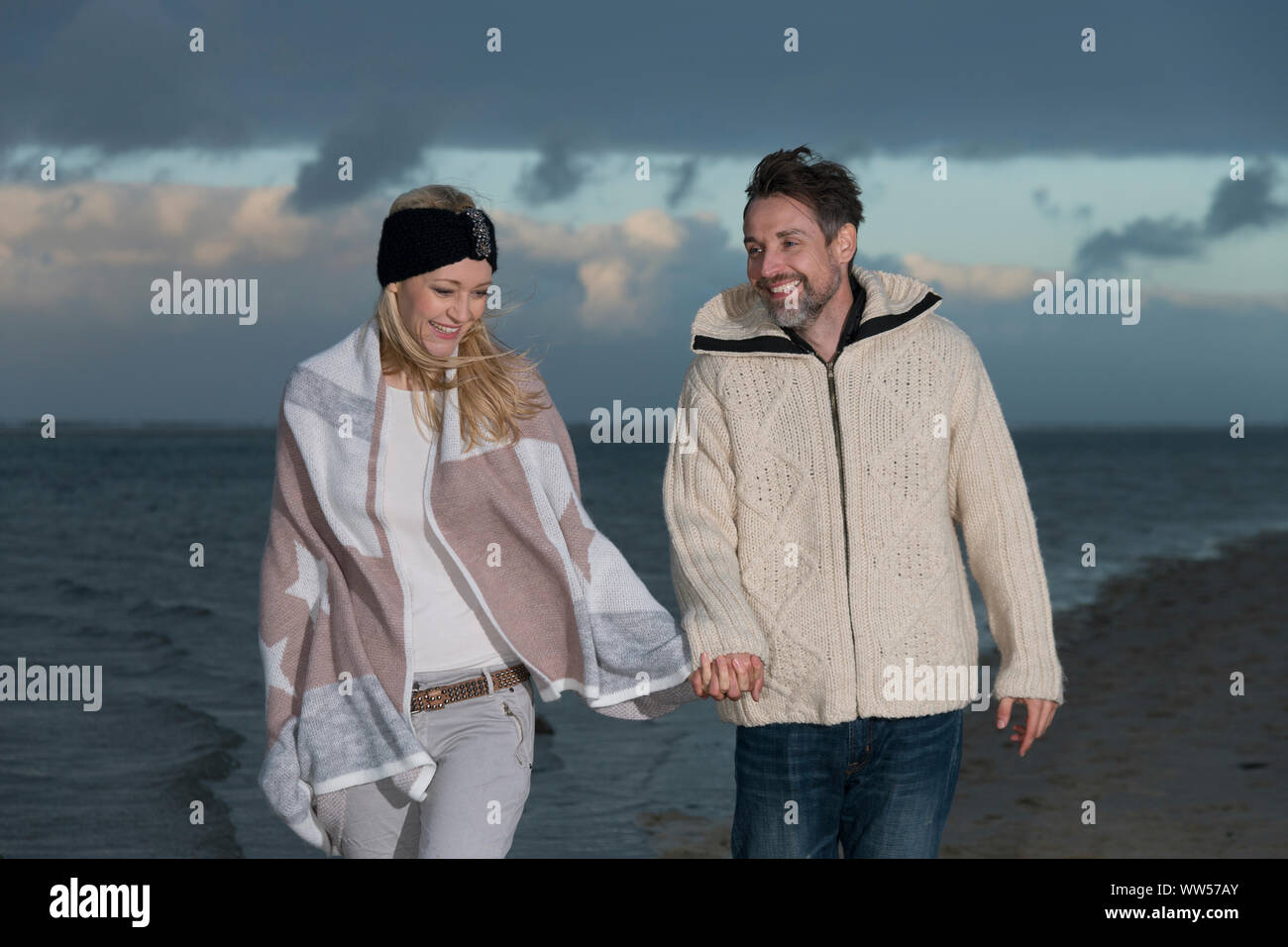 Couple holding hands by the sea Stock Photo - Alamy