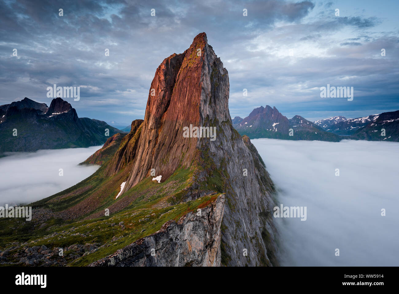 View on Iconic Mountain Segla in morninglight over a sea of mist and clouds, Fjordgard, Senja, Norway Stock Photo