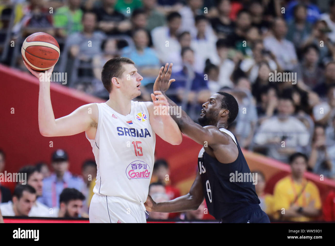 Nikola Jokic of Serbia, left, keeps the ball during the 5th – 8th classification round against the United States of FIBA Basketball World Cup in Dongguan, south China's Guangdong province, 12 September 2019. The United States is beaten by Serbia with 94-89 at 5th – 8th classification round of FIBA World Cup in Dongguan, south China's Guangdong province, 12 September 2019. Stock Photo