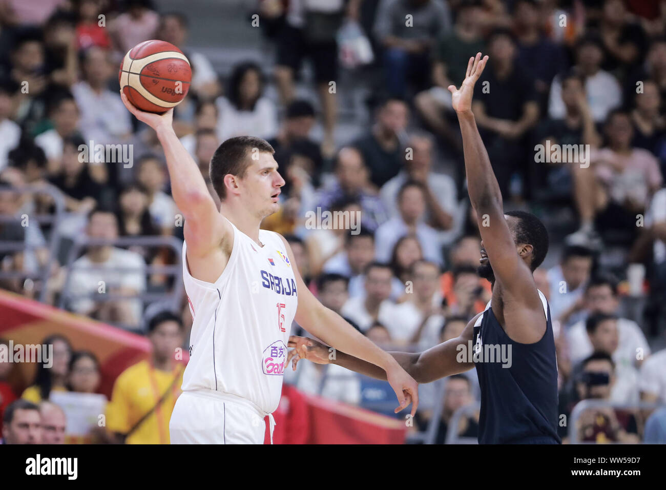 Nikola Jokic of Serbia, left, keeps the ball during the 5th – 8th classification round against the United States of FIBA Basketball World Cup in Dongguan, south China's Guangdong province, 12 September 2019. The United States is beaten by Serbia with 94-89 at 5th – 8th classification round of FIBA World Cup in Dongguan, south China's Guangdong province, 12 September 2019. Stock Photo