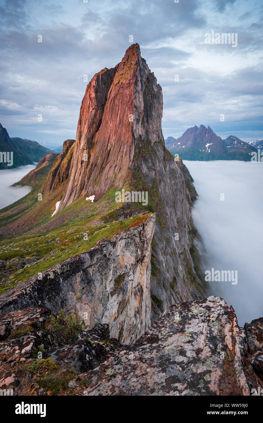 View on Iconic Mountain Segla in morninglight over a sea of mist and clouds, Fjordgard, Senja, Norway Stock Photo