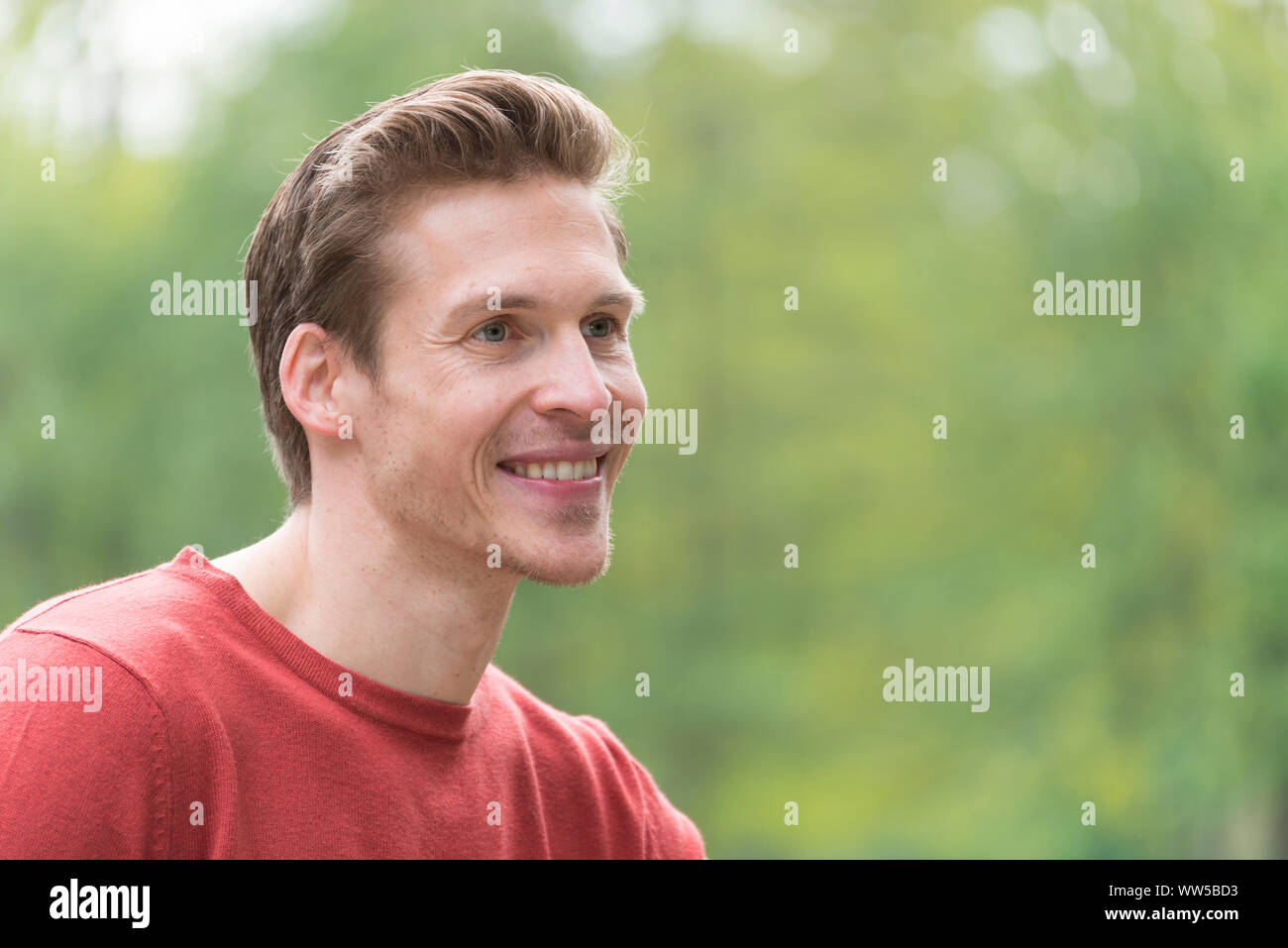Man in red sweater, looking sideways, portrait, Stock Photo