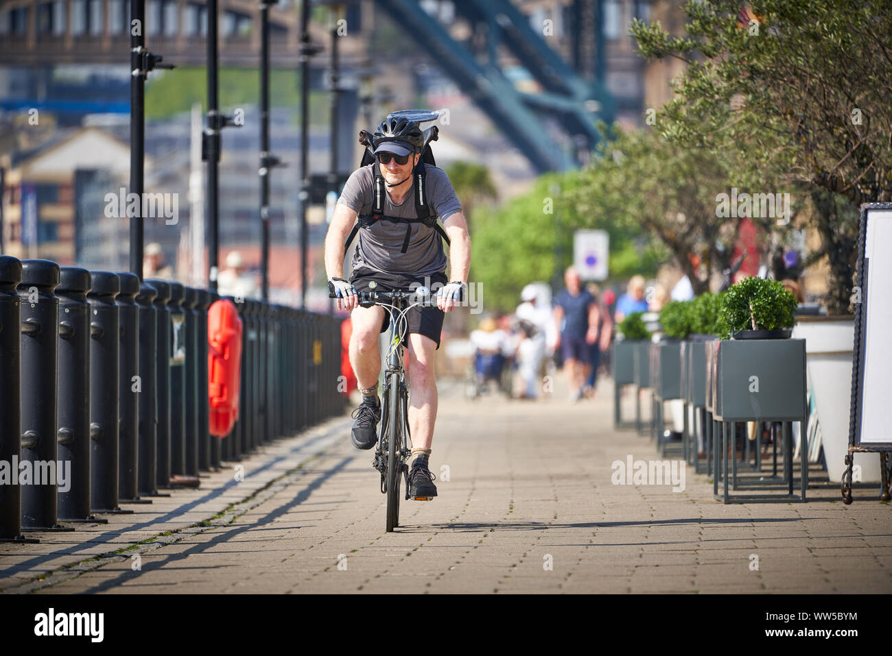 NEWCASTLE UPON TYNE, ENGLAND, UK - MAY 08, 2018: A cyclists riding along Newcastle Quayside on a sunny day. Stock Photo