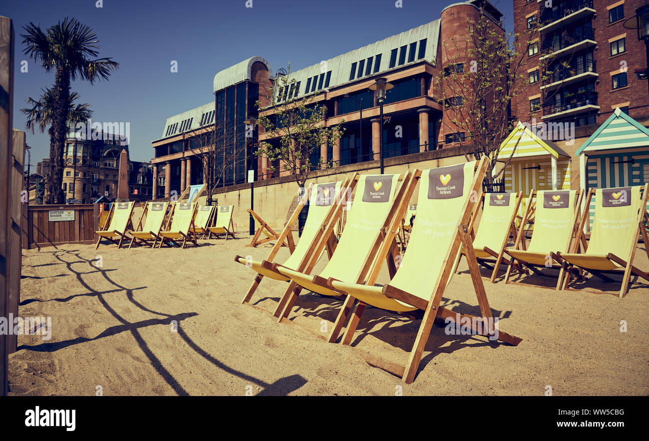NEWCASTLE UPON TYNE, ENGLAND, UK - MAY 08, 2018: Deckchairs at the Thomas Cook Seaside venue on the Newcastle Quayside with the Newcastle Crown Court Stock Photo