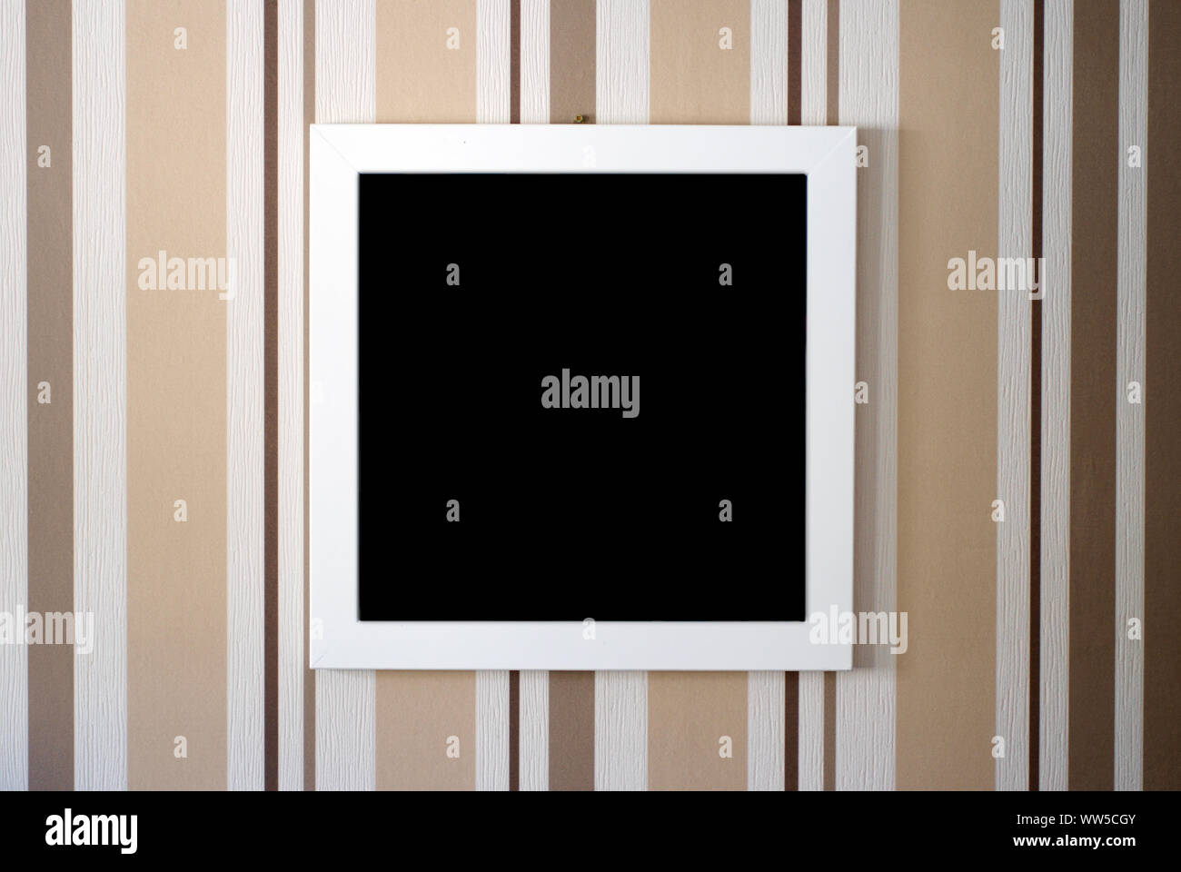 Close-up of a picture frame in front of a strikingly striped wallpaper, Stock Photo