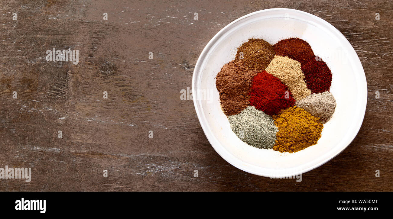 Different kind of spices in bowl for cooking on wooden background. Top view with copy space. Panorama, banner Stock Photo