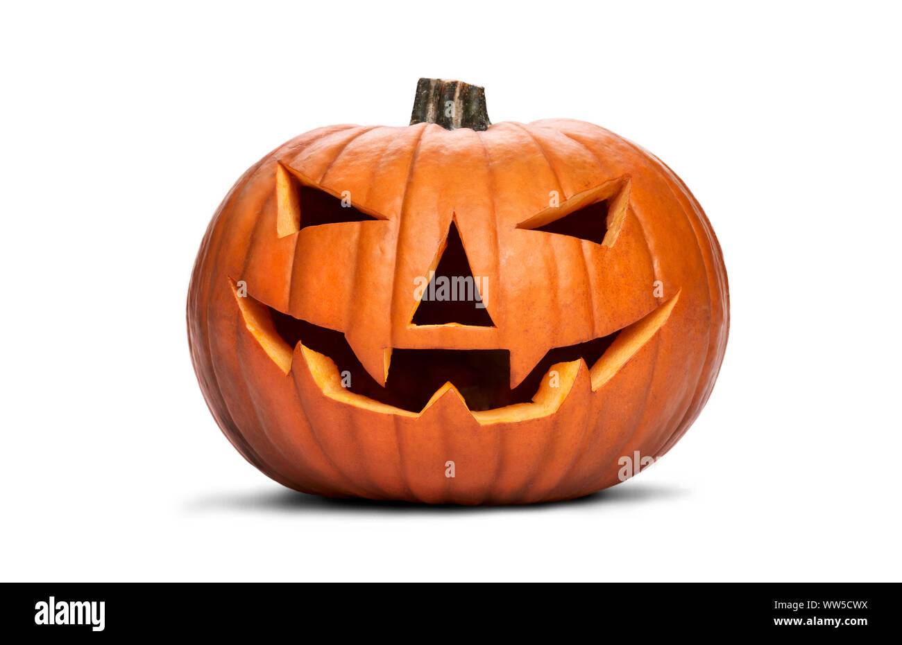 A carved halloween pumpkin with evil eyes and face isolated on white. Stock Photo